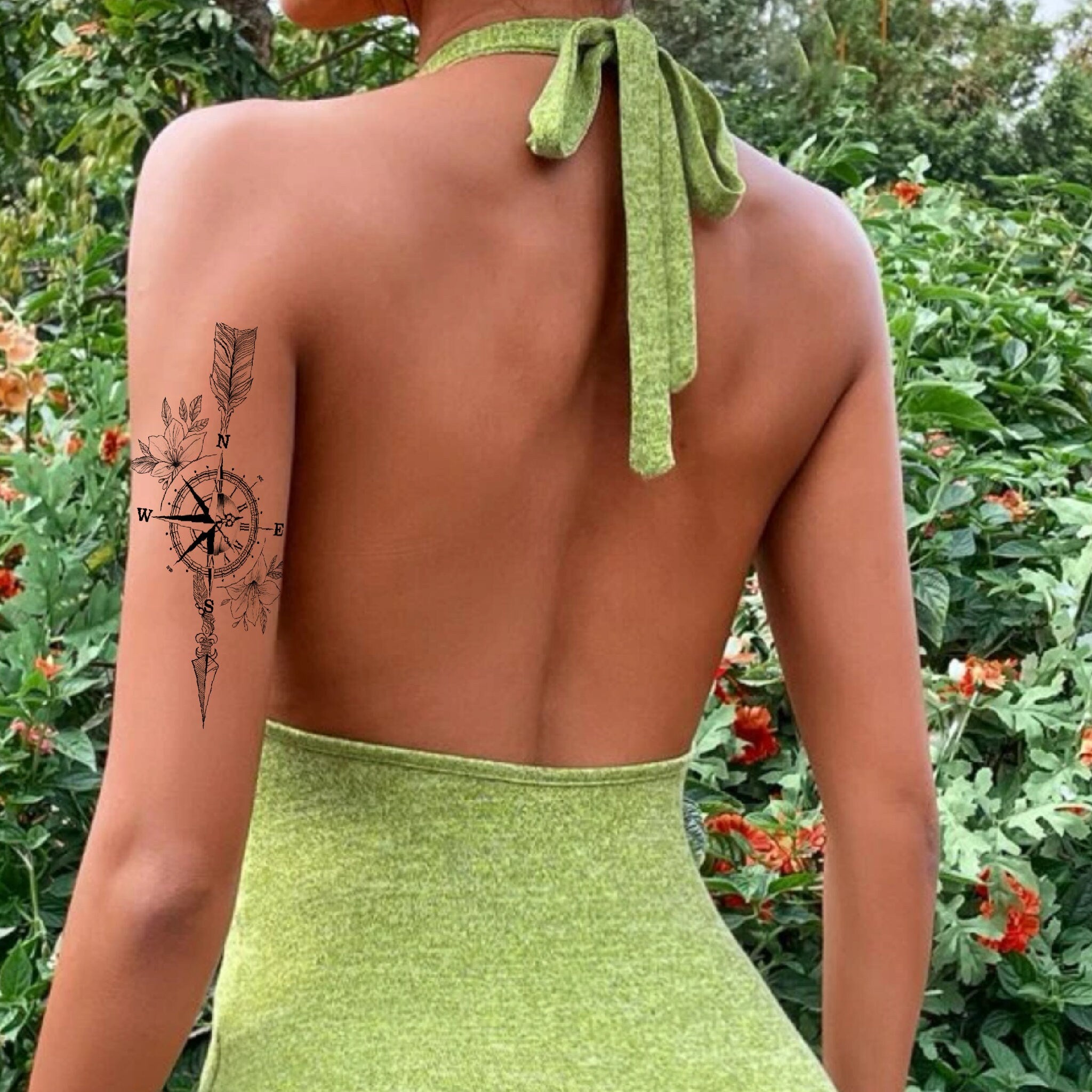 Pine tree compass tattoo on the back of the left arm.